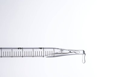 Kozmetik ve tıbbi görüntüler için kullanılabilen bir damlacıktan dökülen temiz sıvı damlacıklar.