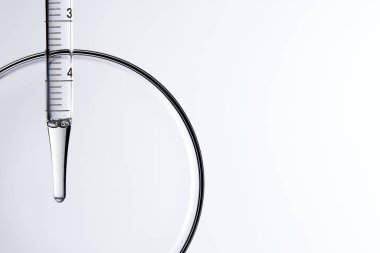 Kozmetik ve tıbbi görüntüler için kullanılabilen bir damlacıktan dökülen temiz sıvı damlacıklar.