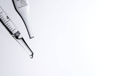 Kozmetik ve tıbbi görüntüler için kullanılabilen bir damlacıktan dökülen temiz sıvı damlacıklar.