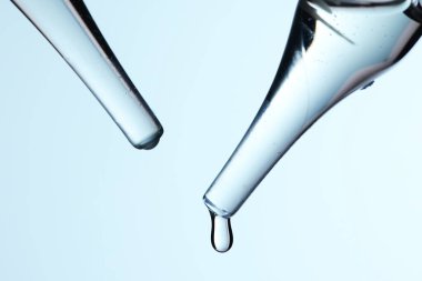 Kozmetik ve tıbbi görüntüler için kullanılabilen bir damlacıktan dökülen temiz sıvı damlacıklar.