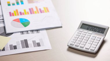 Hesaplama, yönetme ve ekonomik kazanç ve kayıpları hesaplamak için hesap makineleriyle dolu bir masa.