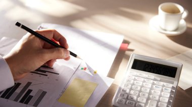 Hesaplama, yönetme ve ekonomik kazanç ve kayıpları hesaplamak için hesap makineleriyle dolu bir masa.