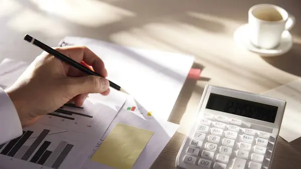 Hesaplama, yönetme ve ekonomik kazanç ve kayıpları hesaplamak için hesap makineleriyle dolu bir masa.