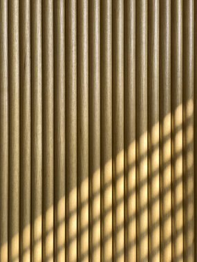 Pencereden içeri gölgeler giren ahşap iç duvar..