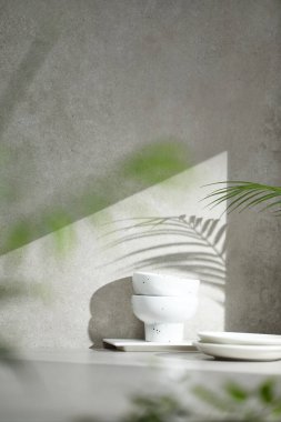 Penceresinden güneş ışığı geçen çeşitli aksesuarları olan gri renkli bir fayans..