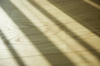 Minimalist bir iç mekan ahşap tonlarda ve sıcak güneş ışığı içeri akıyor..