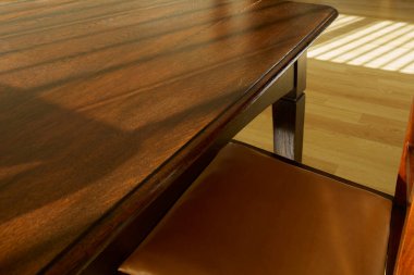 Minimalist bir iç mekan ahşap tonlarda ve sıcak güneş ışığı içeri akıyor..