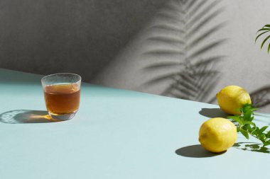 Doğal güneş ışığı ve gölgeli bir masada taze meyve ve çimlerle dolu rahat bir fon..