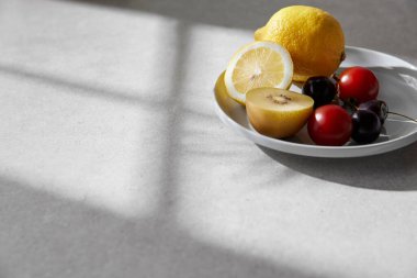 Doğal güneş ışığı ve gölgeli bir masada taze meyve ve çimlerle dolu rahat bir fon..