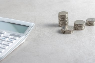 Mali ve ekonomik konsepti olan bir masada madeni paralar ve eşyalar.