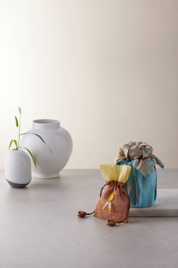 Chuseok için geleneksel Kore bojagi hediye paketi, seramik vazo ve kumaş, ağaç dalları..