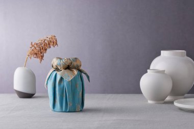 Chuseok için geleneksel Kore bojagi hediye paketi, seramik vazo ve kumaş, ağaç dalları..