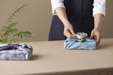 Bojagi (geleneksel Kore kumaşı) kullanan bir kadın. Kore bayramları ve yıldönümleri için yeniden kullanılabilir, el yapımı hediye paketi..