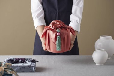 Bojagi (geleneksel Kore kumaşı) kullanan bir kadın. Kore bayramları ve yıldönümleri için yeniden kullanılabilir, el yapımı hediye paketi..