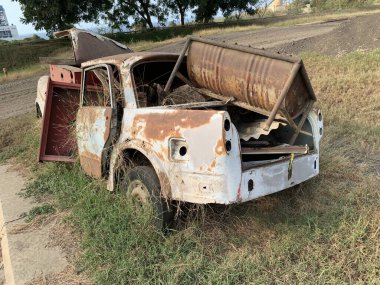 Kırık ve paslı araba uzun zamandır boş bir arsaya park edilmişti. Bu yüzden otla kaplıydı.