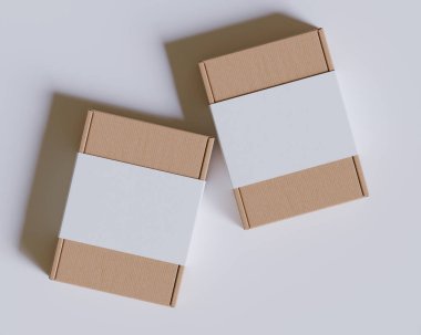 Gri arkaplanda beyaz etiketli kahverengi karton kutular