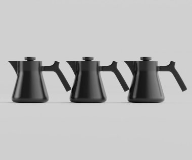 Üç mat siyah çaydanlık nötr gri arka planda yatay sırada dizilir. Çaydanlıkların modern, minimalist bir tasarımı var, pürüzsüz kıvrımları ve basit sapları var. Aydınlatma düz ve parlak, parlak bir son vurguluyor