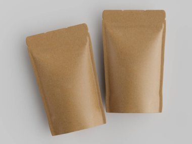 Açık gri bir yüzey üzerinde iki açık kahverengi kağıt kese sergilenir. Keseler yatay olarak ayarlanmış ve biraz üst üste dizilmiş, pürüzsüz yüzey dokusunu ortaya çıkarıyor. Aydınlatma üstümüzde ve üniformalı, gölge yok., 