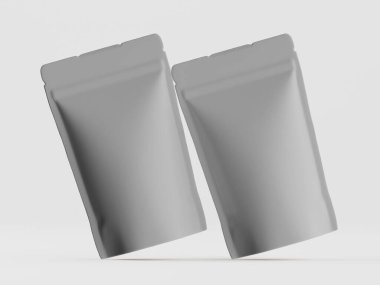 İki gri, boş, esnek paket torbası bir stüdyo ortamında, açık gri arka planda gösteriliyor. Torbaların yatay kıvrımlı kenarları ve pürüzsüz bir mat yüzeyi var. Plastik ya da folyo gibi bir maddeden yapılmış gibi görünüyorlar. Bakış açısı...