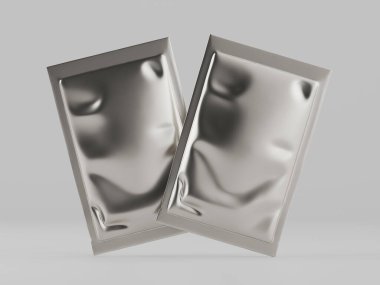 Açık gri bir arka planda iki gümüş folyo paketi sergileniyor. Paketler kırışık yüzeyli dikdörtgen şeklinde. Kozmetik ya da gıda ürünü gibi görünüyor. Görüntü nötr renk düzeniyle iyi ışıklandırılmış. Ticarete elverişli