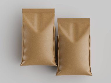 İki açık kahverengi kese kağıdı yüksek açılı bir perspektiften gösteriliyor. Çantalar boyut ve tarz olarak benzer görünüyor. Torbaların pürüzsüz, mat bir dokusu var. Arkalarında düz gri ya da beyaz bir arka plan görülür. Bu fotoğraf yemek için ideal. 