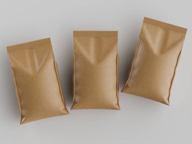 Açık gri bir yüzeye, muhtemelen gıda ürünlerini paketlemek için üç açık kahverengi kâğıt torba yerleştirilmiştir. Torbaların pürüzsüz, hafif desenli bir yüzeyi, katlanmış bir şekli var ve kullanıma hazır görünüyor. Tepeden çekimde tarafsız bir görüntü var.