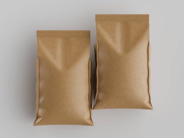 Tarafsız gri arka planda, yiyecek veya diğer ürünler için olması muhtemel iki açık kahverengi kese kağıdı sunuluyor. Çantalar pürüzsüz ve mat bir şekilde yan yana yerleştiriliyor. Tepedeki ışık çantaları aydınlatıyor, üç boyutlarını vurguluyor.