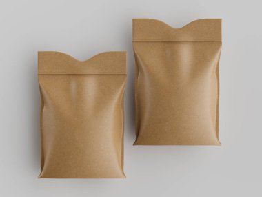 Düz gri arka planda iki açık kahverengi kese kağıdı sergileniyor. Çantalar düz, dikdörtgen ve pürüzsüz, hafif parlak bir yüzeye sahip. Çantaların üstü hafif kıvrımlı ve mühürlü gibi görünüyor. Aydınlatma eşit ve işaret yok.