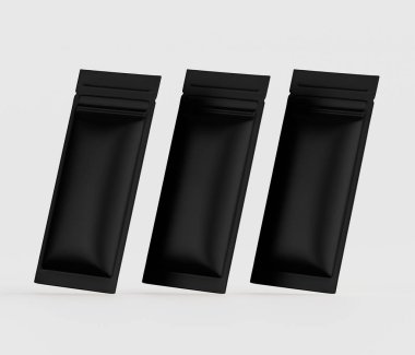 Üç özdeş siyah folyo kesesi nötr gri arka planda sergileniyor. Keseler dikdörtgen şeklinde ve mat siyah bir kapağı var. Biraz üst üste binmiş ve üç boyutlu uzay algısına sahip, sendeleyerek yerleşmiş bir yapıya sahipler.