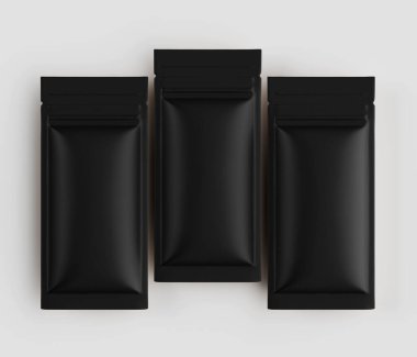 Üç özdeş siyah, mat, dikdörtgen yiyecek paketleme kesesi yatay bir sırada nötr bir arkaplana göre dizilir. Keseler pürüzsüz ve esnek bir malzemeden yapılmış gibi görünüyor. Çelişkili bir rengin küçük bir bölümü t noktasında görünür.