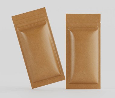 Açık kahverengimsi, dikdörtgen, folyoyla mühürlenmiş iki kese düz gri bir zeminde sunuluyor. Kese yiyecek ambalajı gibi görünüyor, muhtemelen aperatifler veya baharatlar için. Bir stüdyo ortamında tasvir ediliyorlar, pürüzsüz, hatta aydınlatmalı.