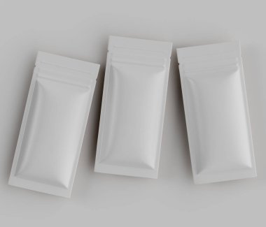 Tarafsız bir arkaplanda üç boş, açık gri kese var. Keseler dikdörtgen şeklinde, pürüzsüz, mat bir kaplama ve modern bir tasarım sergiliyor. Bunlar muhtemelen diğer tüketici malları için boş gıda ambalajı veya ambalajlama. Şey... 