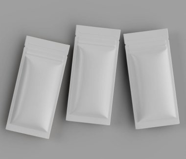 Üç boş, açık gri, dikdörtgen keseler ya da paketler, üst üste dizilmiş, sendeleyerek düzenlenmiş. Kumaş pürüzsüz ve parlak görünüyor, ince bir parıltıyla. Aydınlatma düz ve tepede, belirgin bir gölge oluşturmuyor,