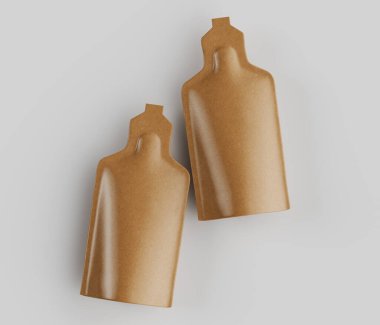 Açık gri arka planda, sıvı veya yarı sıvı ürün olması muhtemel iki açık kahverengi kese sergilenir. Keselerin pürüzsüz, parlak bir kaplaması ve belirgin dikdörtgen şekli var. Aydınlatma eşit, önemli bir gölge bırakmıyor.