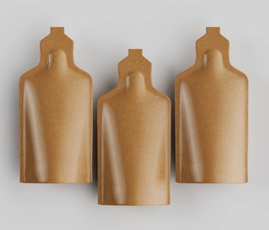 Açık kahverengi, esnek keseler, kozmetik ya da takviye ürünü çağrıştırıyor. Keseler yatay bir sıra halinde, yukarıdan aşağıya doğru sıralanmış ve açık gri bir arkaplanda dikey olarak hizalanmışlardır. Kese pürüzsüz, hafif desenli. 