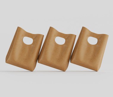 Üç açık kahverengi kese kağıdı, soluk gri arka planda, stüdyo ortamında hafif çapraz olarak düzenlenir. Poşetler dayanıklı bir plastiğe ya da benzer dokuya sahip bir malzemeye benziyor. Resmin bileşimi vurgular