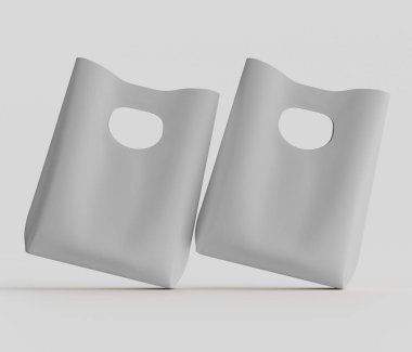 Tepede iki açık gri plastik torba var. Stüdyo çekimlerinde tarafsız bir arkaplanda. Poşetler hafifçe açılı, havada süzülen ya da yükselen bir etkisi var. Çantalar pürüzsüz görünüyor ve üzerinde Han için bir açıklık olan basit bir tasarımı var.