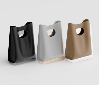 Açık gri bir yüzey üzerinde üç farklı renkte plastik alışveriş torbası sergilenmektedir. Çantaların basit ve modern bir tasarımı var. Çantalar pürüzsüz, mat bir son sergiliyor. Işıklandırma yumuşak ve eşit, kayda değer bir şey yok.