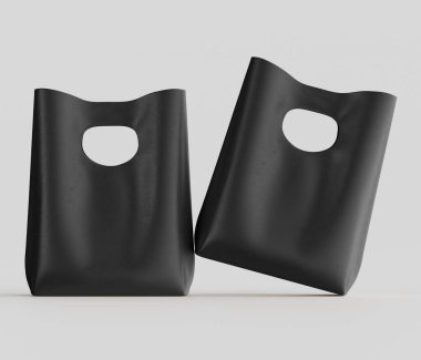 Bir stüdyo ortamında iki siyah plastik alışveriş torbası sunuluyor. Poşetler basit tasarlanmış ve pürüzsüz, mat bir yüzeyi var. Taşımak için kesme kolları var. Tarafsız gri arka plan ve yumuşak ışık torbaları odak noktası yapıyor. T