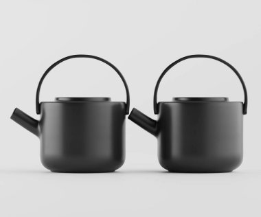 İki modern, siyah seramik çaydanlık tarafsız bir arkaplanda sergileniyor. Çaydanlıklar yuvarlak şekilli, parlak yüzeyli ve aynı tutamaklı basit, minimalist bir tasarıma sahiptir. Stüdyo ortamında yan yana dizilmiş durumdalar.