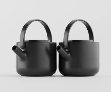 İki özdeş siyah seramik çaydanlık tarafsız, açık gri bir arkaplanda sergileniyor. Tencereler modern tasarım, yuvarlak şekiller ve basit saplar içeriyor. Aydınlatma düz ve parlak, seramoninin pürüzsüz, mat yüzeyini gösteriyor.