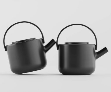Stüdyoda açık gri arka planda iki siyah çaydanlık sunuluyor. Çaydanlıklar tasarım açısından basittir, yuvarlak şekiller ve pürüzsüz yüzeyler içerir. Görüntüye hafifçe odaklanmış durumdalar. Işıklandırma yumuşak ve eşit, crea