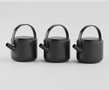 Üç küçük, mat siyah çaydanlık yatay sırada dizilir. Her çaydanlık yuvarlak bir gövdeye, basit bir kapağa ve bir sapa sahiptir. Pürüzsüz, koyu gri-siyah yüzeyin mat bir sonu var ve görünür bir deseni yok. Görüntü yukarıdan çekilmiş., 