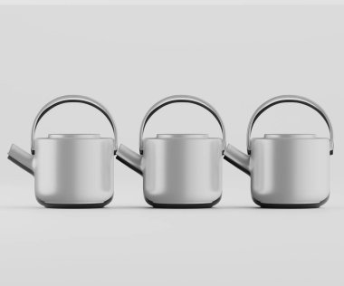 Tarafsız bir arkaplan karşısında üç modern çaydanlık yatay sırada dizilir. Çaydanlıklar düz, yuvarlak şekilli açık gri veya gümüş renktedir. Basit ve çağdaş bir tasarım sergiliyorlar. Sapları ve çıkıntıları var. Görüntü bir şeyi çağrıştırıyor 