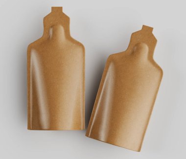 Açık kahverengimsi altın rengi iki kese, açık gri arka planda bir stüdyoda gösteriliyor. Keselerin pürüzsüz, hafif parlak bir dokusu ve yuvarlak, şişe şeklinde bir şekli var. Aydınlatma düz ve tepede, dokuyu ve şekli vurguluyor. 