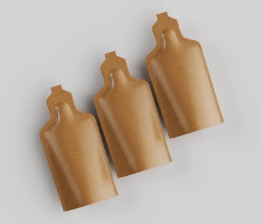 Üç altın renkli, kese şeklinde konteynır, açık gri arkaplana karşı çekilen bir stüdyoda sunuluyor. Konteynırlar düzgün şekilli ve pürüzsüz, parlak bir maddeden yapılmış gibi görünüyor. Aydınlatma eşit ve parlak.