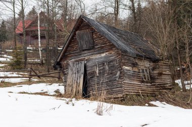 Abandoned cabin in mountain forest with snow