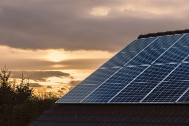Çatıdaki fotovoltaik güneş enerjisi panelleri temiz sürdürülebilir elektrik üretiyor.