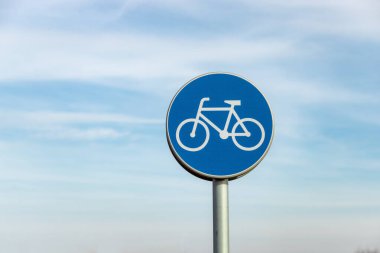 Mavi gökyüzü arkaplanlı bisiklet yolu işareti