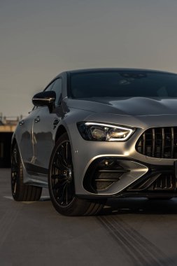 Park alanındaki lüks, güçlü bir arabanın ön görüntüsü.